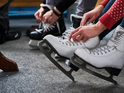 2 people lacing up skates